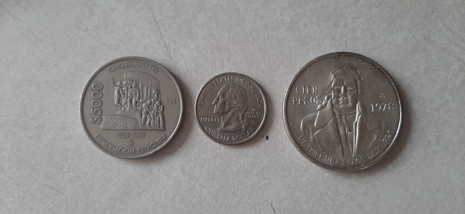 5,000 mexican pesos 1988, a US quarter and a 1978 100 mexican pesos coin.